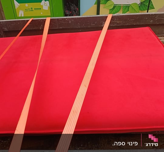 מזרן אדום עם רצועות קשירה על משטח